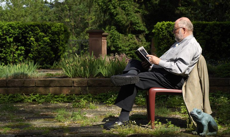 Klaus Tschira liest im Garten ein Buch